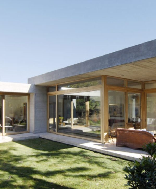 Casa modular moderna con estructura de concreto, ventanales amplios y acabados de madera, diseñada por Modulares S&R
